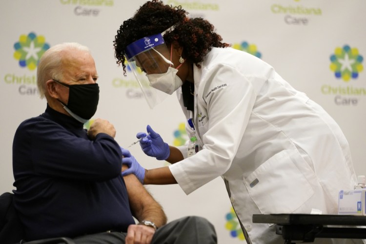 President-elect Joe Biden receives his first dose of the coronavirus vaccine at ChristianaCare Christiana Hospital in Newark, Del., Monday, Dec. 21, from nurse practitioner Tabe Mase. 