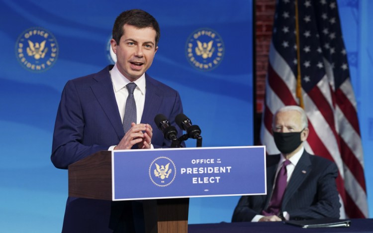 Former South Bend, Ind., Mayor Pete Buttigieg, President-elect Joe Biden's nominee to be transportation secretary, reacts to his nomination as Biden looks on during a news conference at The Queen theater in Wilmington, Del., on Wednesday.