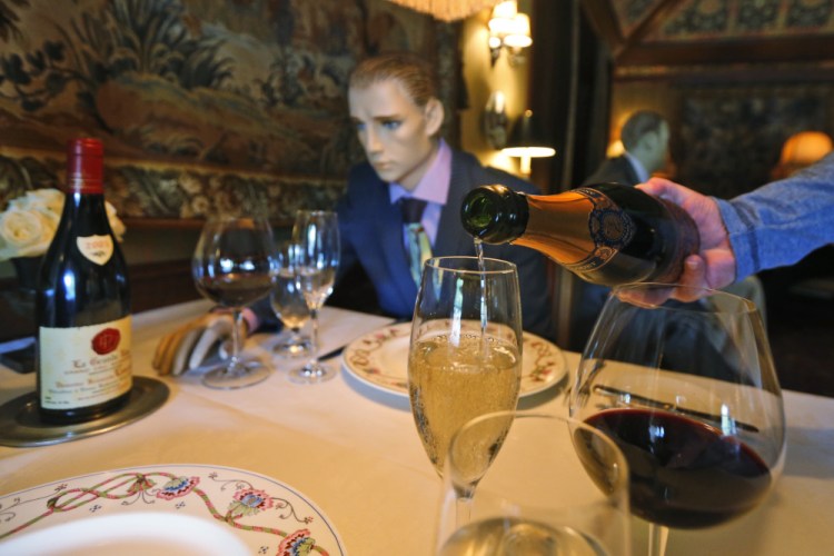 Champagne is poured at a table where mannequins will provide social distancing at the Inn at Little Washington as they prepare to reopen their restaurant in Washington, Va. (AP Photo/Steve Helber, File)