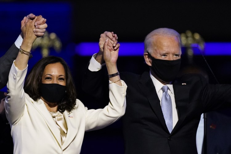 Vice President-elect Kamala Harris holds hands with President-elect Joe Biden after winning the election in November. Biden and Harris have been named Time magazine's Person of the Year. 