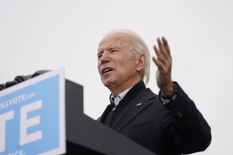 President-elect Joe Biden speaks at a drive-in rally for Georgia Democratic candidates for U.S. Senate Raphael Warnock and Jon Ossoff on Tuesday in Atlanta. Electors  formally cast votes on Monday affirming Biden's victory.