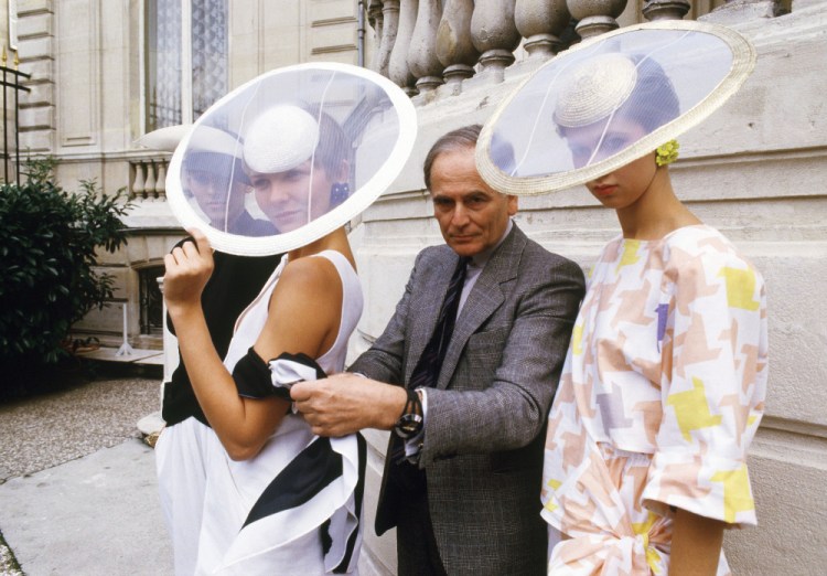 Paris couturier Pierre Cardin and models wearing ensembles from the summer 1985 ready-to-wear Cardin collection pose in Paris, in summer 1984. 
