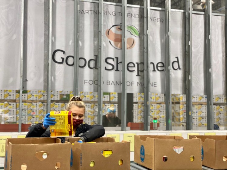 A worker packs food boxes at Good Shepherd Food Bank in Auburn. A mystery donor offered $1 million as a matching grant that was recently fully met.