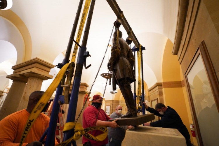Workers remove a statue of Confederate Gen. Robert E. Lee from the National Statuary Hall Collection in Washington on Monday. The statue has represented Virginia in the U.S. Capitol for 111 years and was removed after a state commission decided that Lee was not a fitting symbol for the state.