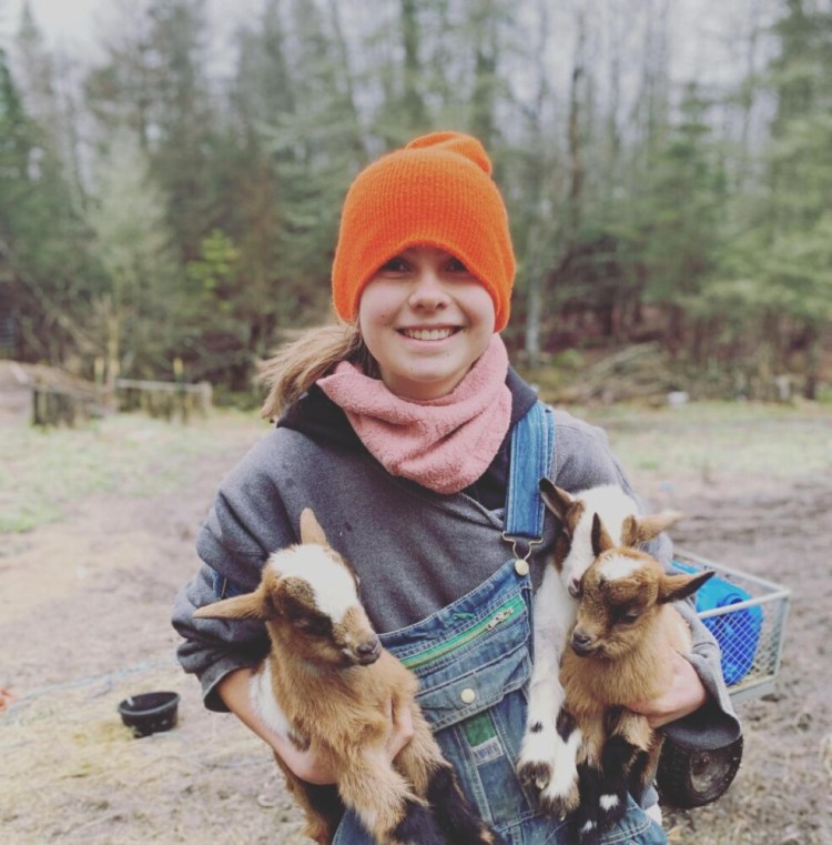 Margaret Mae Reilich holds goats at Painted Pepper Farm in Steuben. The farm will use the grant to invest in a farm stand that will enable safe and easy on-farm pick up.