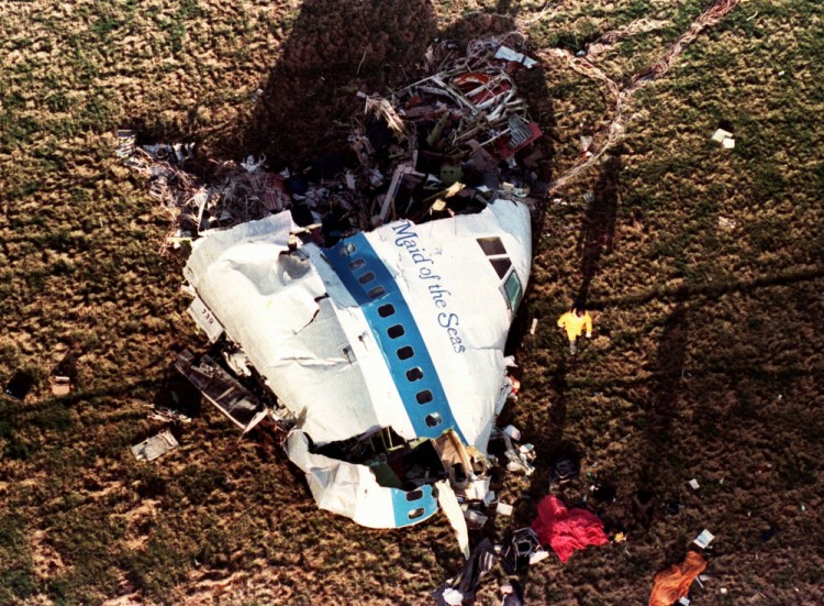 Police and investigators look at what remains of the nose of Pan Am 103 in a field in Lockerbie, Scotland in a Dec. 22, 1988 file photo. The Justice Department expects to unseal charges in the coming days in connection with the 1988 bombing of a Pan Am jet that exploded over Lockerbie, Scotland, killing 270 people, according to a person familiar with the case. 