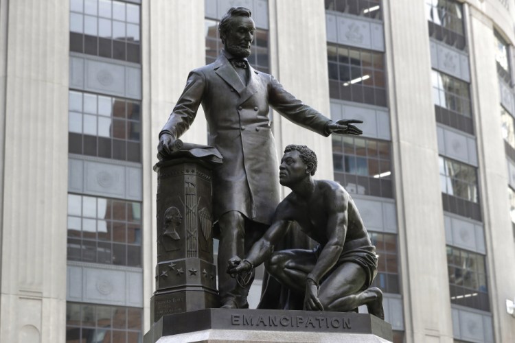 The statue that depicts a freed slave kneeling at President Abraham Lincoln's feet rests on a pedestal in Boston. 