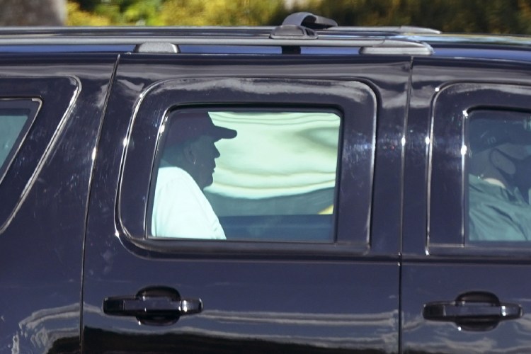 President Trump rides in a motorcade vehicle as he departs Trump International Golf Club on Sunday in West Palm Beach, Fla. 

