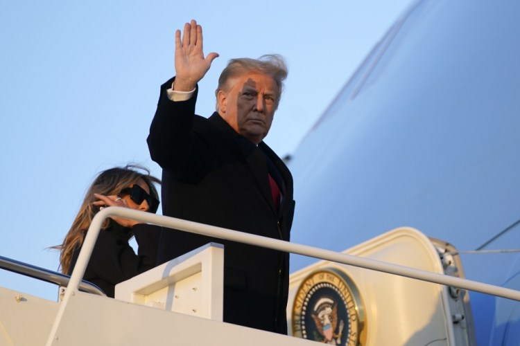 President Trump waves as he boards Air Force One at Andrews Air Force Base, Md., on Wednesday to travel to his Mar-a-Lago resort in Palm Beach, Fla. He hinted he may veto the COVID-19 relief bill, which was sent to his desk for signature on Thursday.