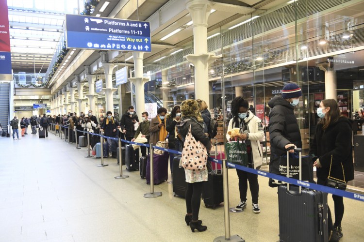 People at St Pancras station in London wait to board the last train to Paris on Sunday.  British Prime Minister Boris Johnson said Saturday that holiday gatherings can’t go ahead and non-essential shops must close in London and much of southern England, leading to a rush of people looking to leave the region. 