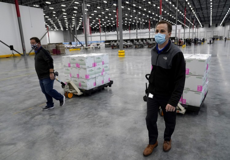 Boxes containing the Moderna COVID-19 vaccine are moved to the loading dock for shipping at the McKesson distribution center in Olive Branch, Miss., on Sunday. 