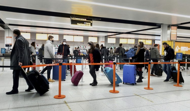Passengers queue for check-in at Gatwick Airport Dec. 20 in West Sussex, England, south of London. 