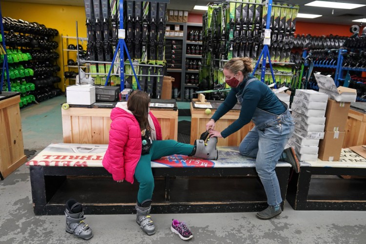 Meredith Hopkins, right, helps fit ski boots on Makenna Houghton at the ski shop at McIntyre Ski Area on Wednesday in Manchester, N.H. 

