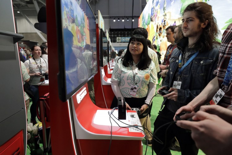 Visitors to the Pax East conference play the new Nintendo Switch video game Animal Crossing, Feb. 27 in Boston.