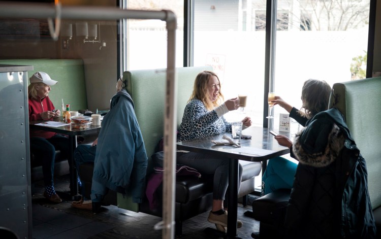Dawn Kaphingst, left, toasts to her cousin Jane Murray's birthday as the two get together for the first time since summer at Longfellow Grill in Minneapolis on Monday, the first day restaurants were allowed to reopen, at 50 percent capacity. 