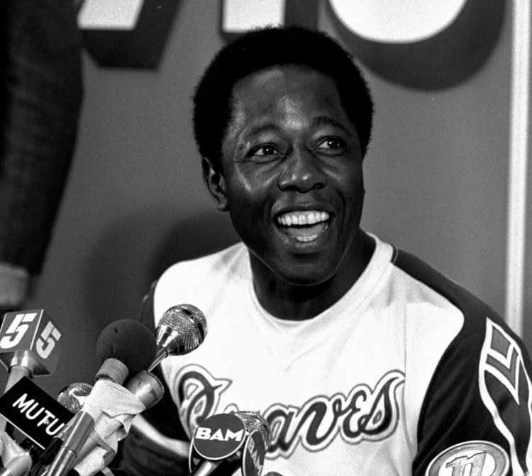 FILE - Atlanta Braves' Hank Aaron smiles during a press conference following a baseball game against the Los Angeles Dodgers where Aaron hit his 715th career home run in Atlanta, in this Monday night, April 8, 1974, file photo. Hank Aaron, who endured racist threats with stoic dignity during his pursuit of Babe Ruth but went on to break the career home run record in the pre-steroids era, died early Friday, Jan. 22, 2021. He was 86. The Atlanta Braves said Aaron died peacefully in his sleep. No cause of death was given. (AP Photo/File)