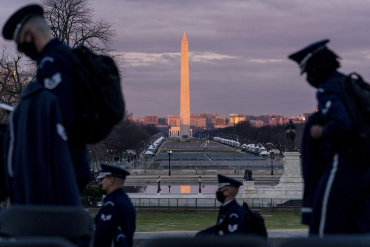 The Washington Monument and the National Mall are visible as members of the U.S. Air Force Honor Guard walk along the West Front of the U.S. Capitol at the site of the 59th Presidential Inauguration in Washington on Monday. (AP Photo/Andrew Harnik)