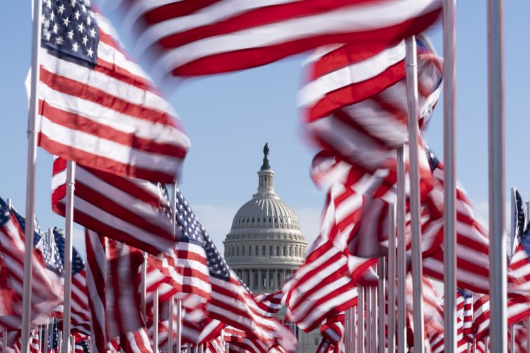 The U.S. Capitol is seen between flags placed on the National Mall ahead of the inauguration of President-elect Joe Biden and Vice President-elect Kamala Harris, Monday, Jan. 18, in Washington. 