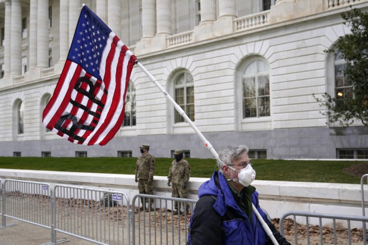 A protester walks past the Russell Senate Office Building on Capitol Hill in Washington on Friday. There may be volatility ahead for the Republican Party as it braces for political fallout from the riot that Trump incited. 