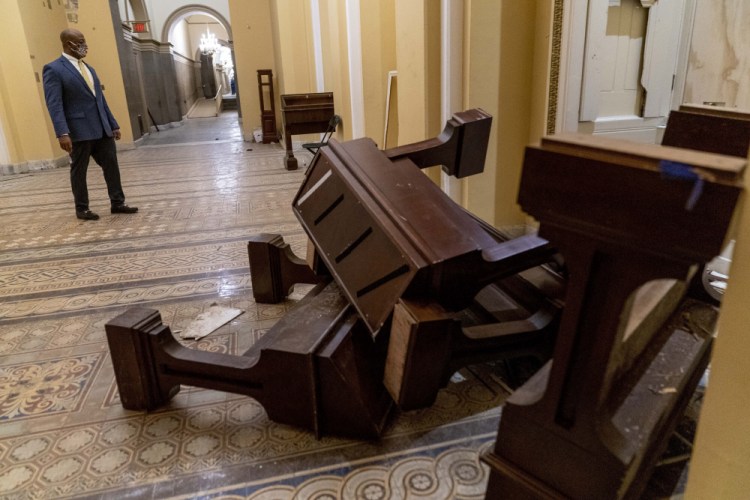 The U.S. Capitol was damaged in the Jan. 6 riot. A laptop is believed to have been stolen from the office of House Speaker Nancy Pelosi by a rioter. Here, Sen. Tim Scott, R-S.C., surveys the damage on Jan. 7.