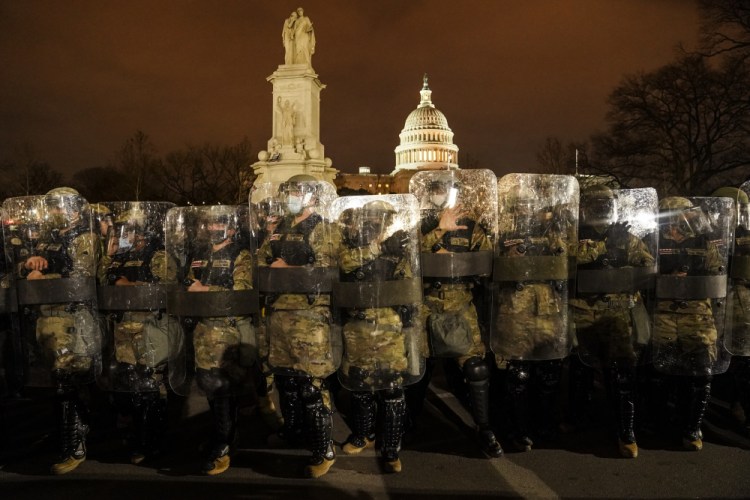 District of Columbia National Guard members stand outside the Capitol on the night of Jan. 6, after a day of rioting protesters. 