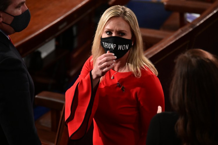 Rep. Marjorie Taylor Greene, R-Ga., wears a "Trump Won" face mask as she arrives on the floor of the House to take her oath of office on opening day of the 117th Congress at the U.S. Capitol on Sunday. Taylor Greene is one of a dozen elected officials who seek to overturn presidential election results.
