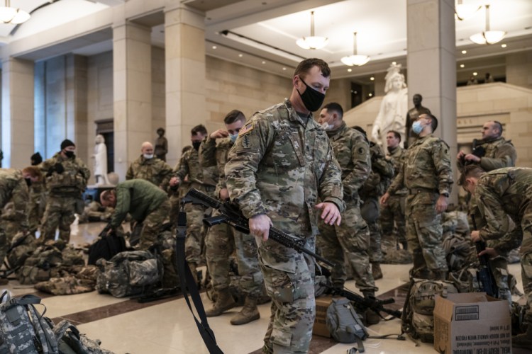 Hundreds of National Guard troops are stationed inside the Capitol Visitor's Center to reinforce security at the Capitol in Washington on Wednesday. The House of Representatives is pursuing an article of impeachment against President Trump for his role in inciting an angry mob to storm the Capitol last week. 