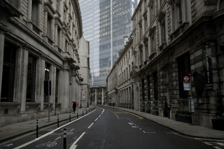 A lone pedestrian walks in the City of London financial district on Monday, the first morning of England entering a third national lockdown since the coronavirus outbreak began.