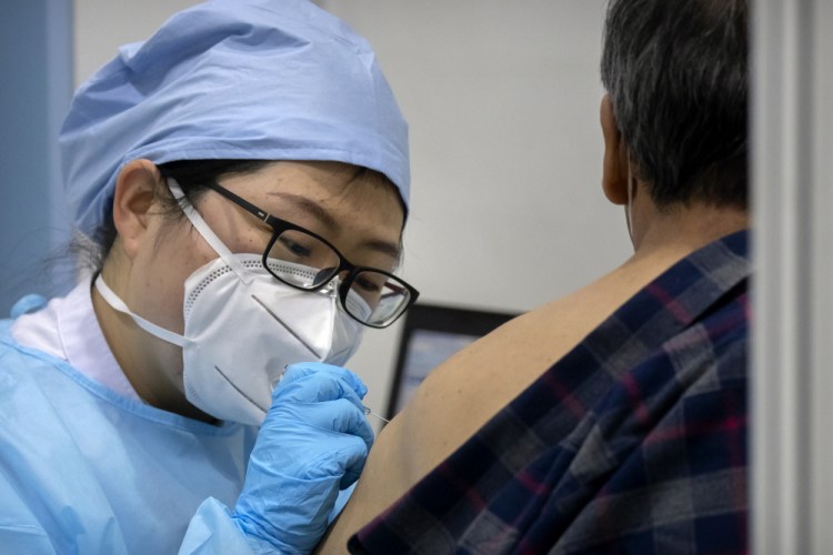 A medical worker gives a coronavirus vaccine shot to a patient in Beijing on Friday.

