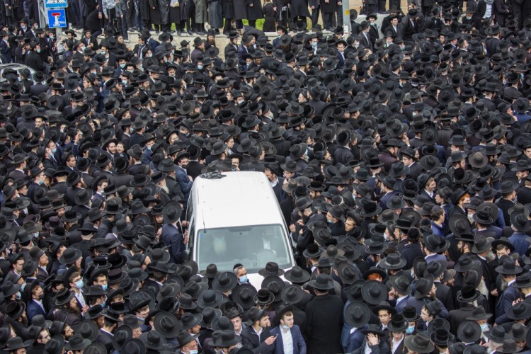 Thousands of ultra-Orthodox Jews participate in the funeral for prominent rabbi Meshulam Soloveitchik in Jerusalem on Sunday.  Israel restricts outdoor gatherings to 10 people. (AP Photo/Ariel Schalit)