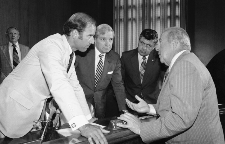 In this July 13, 1982, file photo Secretary of State designate George Shultz, right, speaks with members of the Senate Foreign Relations Committee. From left are Sen. Joseph Biden, D-Del.; Sen. Charles Percy, R-Ill., chairman of the panel, and Sen. Edward Zorinsky, D-Neb. (AP Photo/Ira Schwarz, File)
