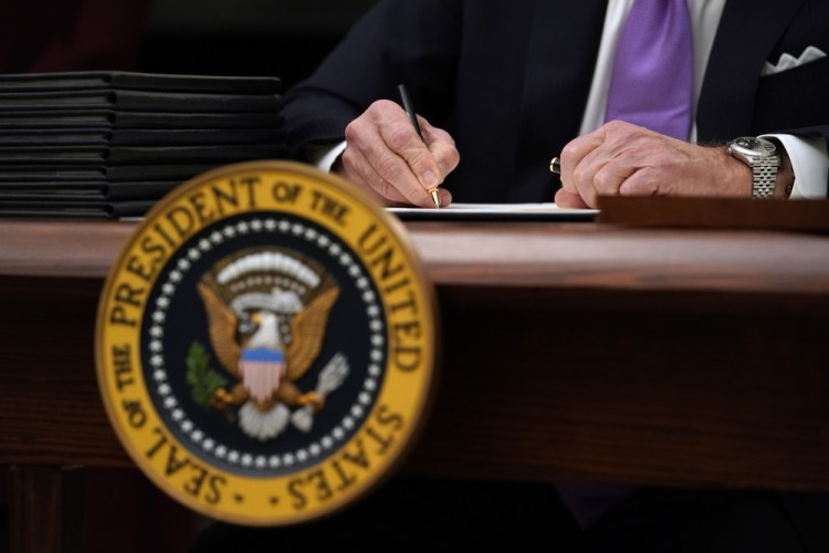 President Biden signs executive orders Thursday at the White House. 
