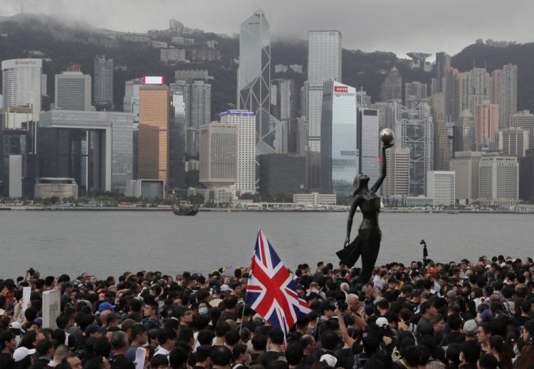 Thousands of protesters carrying the British flag march near the harbor of Hong Kong on July 7, 2019. The British government estimates more than 300,000 Hong Kongers will take up the offer of extended residency rights in the United Kingdom in the next five years.