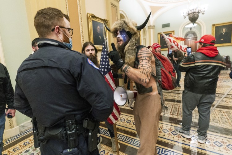 Jacob Anthony Chansley, who also goes by the name Jake Angeli, is shown during the Capitol riot on Jan. 6. Prosecutors say he left a note threatening Vice President Mike Pence, who had been evacuated from the Senate chamber.