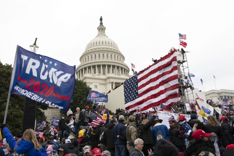 Supporters of President Trump stand outside the U.S. Capitol in Washington on Jan. 6 before storming the building. Lawyers interviewed by the Associated Press agreed that it would be stretch to try to put Trump or lawyer Rudolph Giuliani on trial for sedition for what some have criticized as incendiary rhetoric at the rally preceding the mob attack on the Capitol.