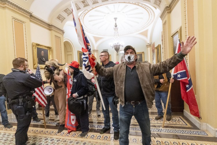 Supporters of former President Trump are confronted by U.S. Capitol Police officers outside the Senate Chamber inside the Capitol in Washington on Jan. 6. Dozens of people have been charged in connection with the riot. 