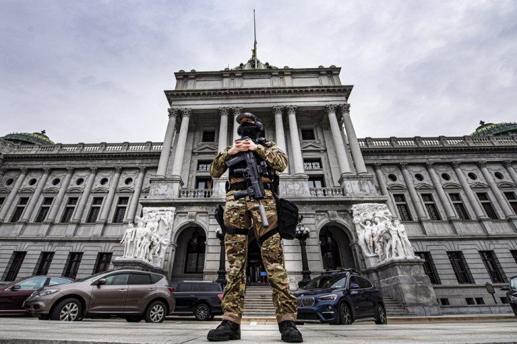 A member of the Pennsylvania Capitol Police stands guard at the entrance to the Pennsylvania Capitol Complex in Harrisburg on Wednesday.

