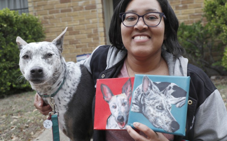 Danielle Moore poses for photos with Kana and also paintings of the pet Australian cattle dog in Dallas on March 2.
