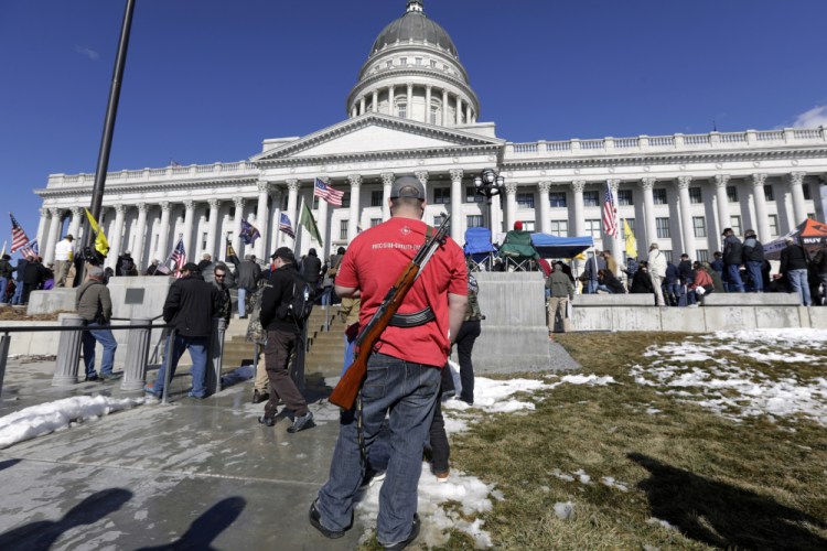 A man carries his weapon during a second amendment gun rally at the Utah State Capitol on Feb. 8, 2020, in Salt Lake City. Utah is one of several more states weighing proposals this year that would allow people to carry concealed guns without having to get a permit. 
