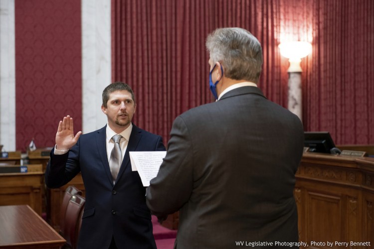 West Virginia House of Delegates member Derrick Evans, left, is given the oath of office last month in the House chamber at the state Capitol in Charleston, W.Va. Evans recorded video of himself and fellow supporters of President Trump storming the U.S. Capitol in Washington, D.C., on Wednesday. 