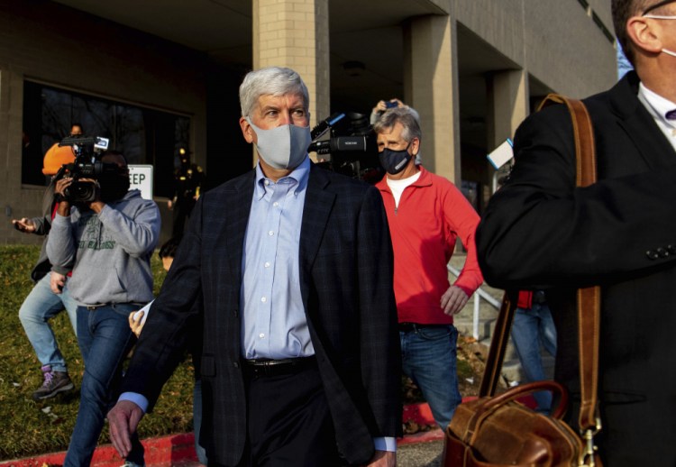 Former Gov. Rick Snyder walks past the media after his video arraignment on charges related to the Flint water crisis on Thursday outside the Genesee County Jail in downtown Flint.  Snyder pleaded not guilty to misdemeanor charges of willful neglect of duty in Flint. 