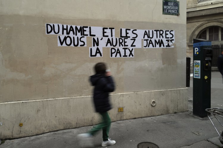 A sign reads "Duhamel, and the others, you will never be in peace," referring to prominent French political expert Olivier Duhamel, in Paris, on Tuesday.


