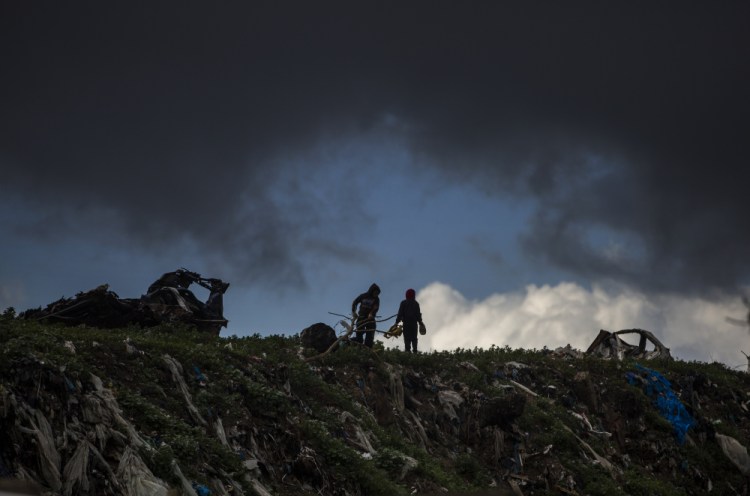 Two Palestinian boys play on top of piles of garbage on a rainy day in a poor neighborhood of Khan Younis, in the southern Gaza Strip, Wednesday, Jan. 20. 