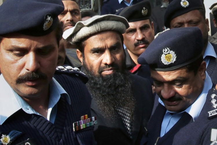 Pakistani police officers escort Zaki-ur-Rehman Lakhvi, center, the main suspect of the Mumbai terror attacks in 2008.
