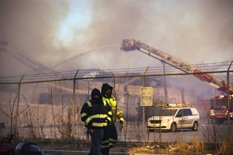 Firefighters battle a blaze in an industrial area on Saturday, in Passaic, NJ. The multi-alarm fire in a recycling plant started after midnight and burned into the morning.
