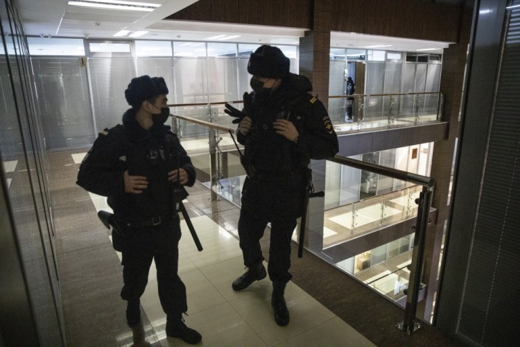 Police stand guard at the Foundation for Fighting Corruption office in Moscow, Russia, Wednesday, Jan. 27. Police are searching the Moscow apartment of jailed Russian opposition leader Alexei Navalny, another apartment where his wife is living and two offices of his anti-corruption organization. Navalny's aides reported the Wednesday raids on social media.