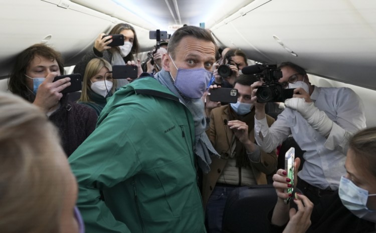 Alexei Navalny is surrounded by journalists inside the plane Jan. 17 prior to his flight to Moscow in the Airport Berlin Brandenburg (BER) in Schoenefeld, near Berlin, Germany. 