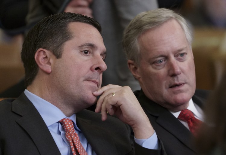 Rep. Devin Nunes, R-Calif, left, the ranking member of the House Intelligence Committee, speaks with then Rep. Mark Meadows, R-N.C., a member of the House Committee on Oversight and Reform, as they sit in the audience as the House Judiciary Committee holds a hearing on the constitutional grounds for the president's impeachment, on Capitol Hill in Washington. 