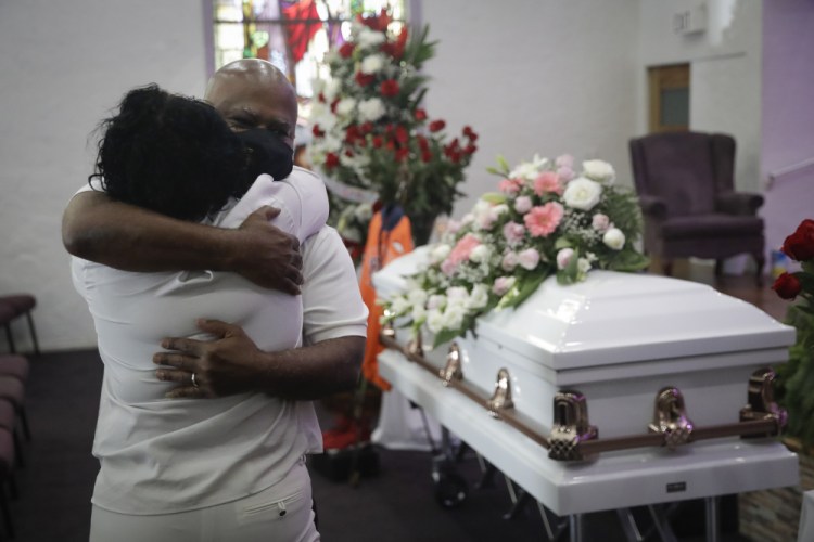 Darryl Hutchinson, facing camera, is hugged by a relative during a funeral service for Lydia Nunez, who was Hutchinson's cousin at the Metropolitan Baptist Church in Los Angeles. 


