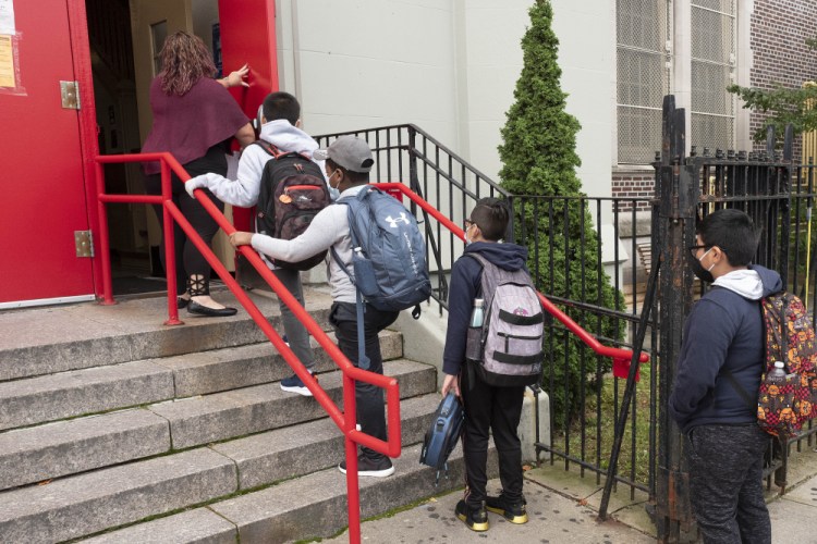 A teacher leads her students into an elementary school in the Brooklyn borough of New York in September 2020.